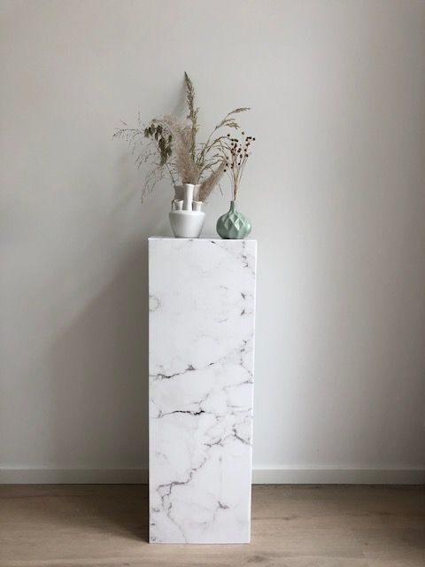 Cardboard pillar with white marble print. A real eye-catcher to show accessories and products. Easy to fold, unfold, use, reuse and to carry.